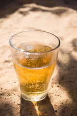 a glass of Cold beer on the beach sand