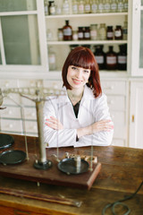 Perfect medication. Shot of a young beautiful pharmacist working with old scales in the lab of pharmacy.