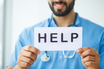 Health Care. Doctor Holding a Card With Symbol HELP, Medical Concept