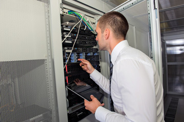 Fototapeta premium Young handsome business man engeneer in datacenter server room