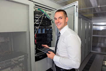 Fototapeta premium Young handsome business man engeneer in datacenter server room