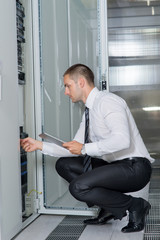 Young handsome business man engeneer in datacenter server room