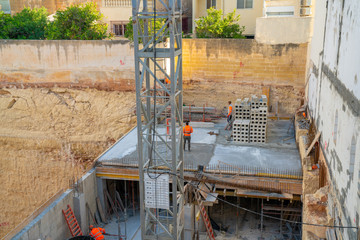 May 10, 2018. Valletta, Malta. Group of workmen wearing protective helmets and vests building a...