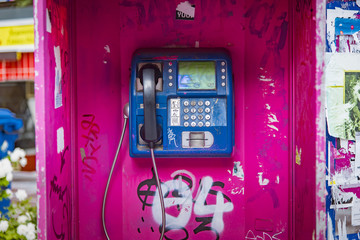 Old magenta phone booth sprayed with graffiti in Thessaloniki, Greece, unused for a long time - obrazy, fototapety, plakaty
