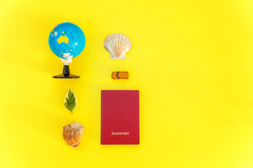 Flat Lay with passport, globe, sunglasses and shell on yellow colourful trendy modern fashion background. Vacation travel summer weekend sea adventure trip concept