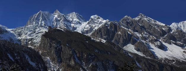 Hailuogou Glacier Park scenery - Gongga Snow Mountain National Park in Sichuan Province, China. Snow Mountain/Glacier scenery and mountain cliffs. Snow Mountains, frosty ice, clouds and blue sky.