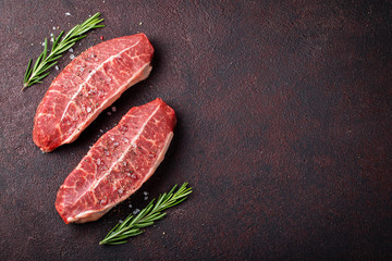 Raw fresh meat Top Blade steaks on dark background. top view with copy space