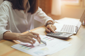 Businesswoman in office and use computer and calculator to perform financial accounting. To plan advance budget.