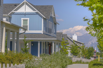 Baby blue house in neighborhood with sidewalk