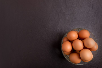 Fresh farm eggs on black stone background,top view with copy space