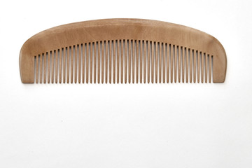 closeup brown wooden comb on a white background