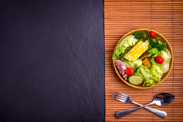 Salad healthy food on wood and black stone background. Weight loss. Copy space.