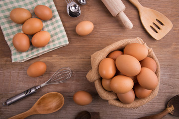 Fresh farm eggs on a wooden rustic background, Whipping eggs and whisk,top view with copy space