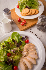 Vertical Grilled turkey salad on white dish on old wooden table.
