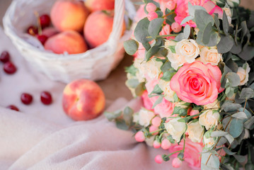 Peaches in white basket and roses bouquet