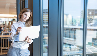 Young woman holding a laptop computer.