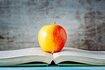red apple on open book