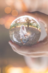 woman holding basket while walking through a grove seen in a crystal ball