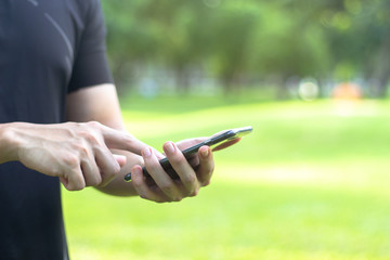 Close up of a man using black mobile smart phone with copy space for text