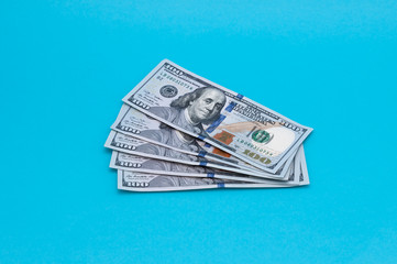 Five hundred American dollars in bills of one hundred dollars on a blue background.