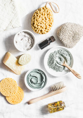 Fototapeta na wymiar Spa accessories - nut scrub, sponge, facial brush, natural soap, clay face mask, pumice stone, essential oil on a light background, top view. Healthy lifestyle concept. Beauty, skin care. flat lay