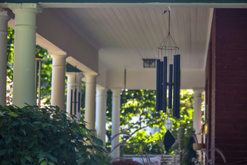 Wind chimes on a house with white pillars
