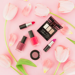 Obraz na płótnie Canvas Beauty composition with tulips flowers and female cosmetics on pink background. Top view. Flat lay.