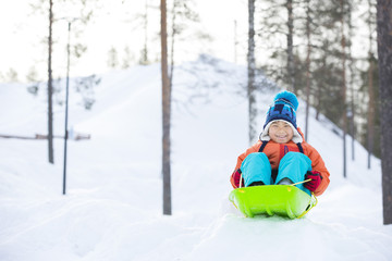 Fototapeta na wymiar 雪景色とソリで遊ぶ子供
