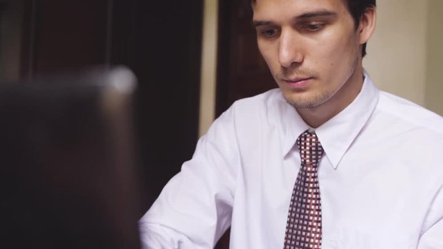 Handsome toung businessman working on an office. Young man typing on a laptop. slwo motion. 3840x2160