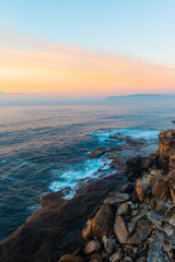 Orange sunrise sky in the rock cliff and ocean.