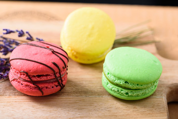 Colourful Macaroons on cutting board with lavender flower