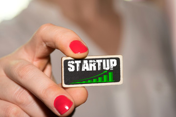 Eine Frau und ein Schild mit dem Aufdruck Startup
