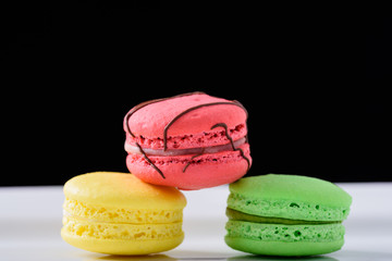 Three Colourful Macaroons against black background