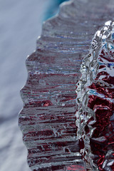 Macro abstract of crystal glass texture with reflecting red and silver color