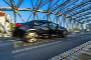 Traffic on steel bridge with skyline at sunset