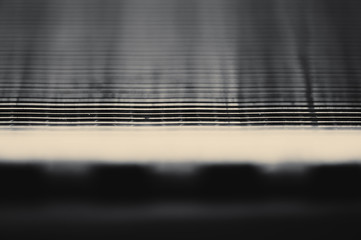 Detailed background of fragment of automotive radiator in macro with copy space. Monochrome image of metallic auto part is close-up. Empty surface of steel texture.