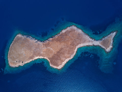 Aerial photo of one uninhabited greek island in mediterranean sea, desert landscape and beautiful azure water around