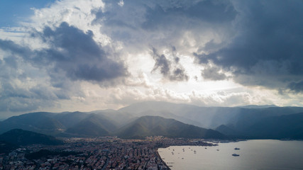 Amaizing view of Marmaris bay in cloudy day with the sun shyning through the clouds, city in the valley