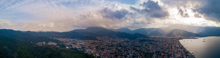 Amaizing view of Marmaris bay in cloudy day with the sun shyning through the clouds, city in the valley