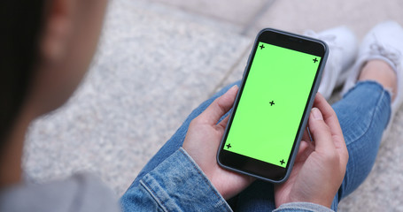 Woman use of mobile phone with green screen, chroma key