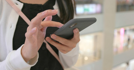 Woman use of smart phone inside shopping center