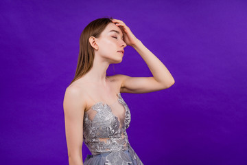 portrait of a beautiful stress woman headache on purple background in studio
