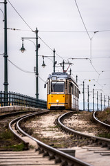 Fototapeta premium Yellow Tram in early winter with cloudy sky
