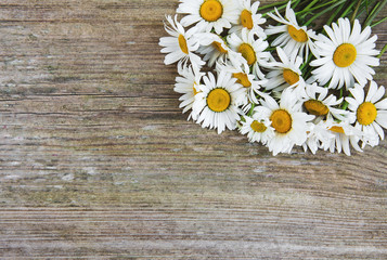 Obraz premium Chamomile flowers on a wooden table
