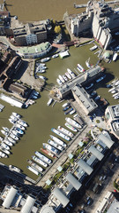 Aerial drone bird's eye view of famous St Katharine Docks Marina and iconic skyline in City of London, United Kingdom