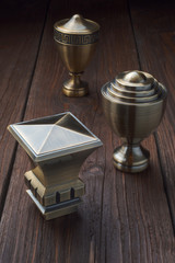 The tips for curtain rails lie on an old wooden table. The metal tips for the cornices lie on an old dark wooden table.