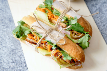 Close up of classical banh-mi sandwich with sliced grilled pork tenderloin, shredded carrots and...