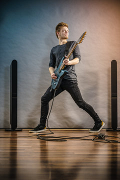 Young man playing electric guitar