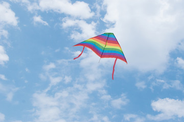 A floating kite in colors lgbt against the sky.