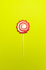 Red and white party lollipop on colored background